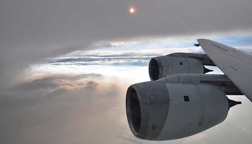 Turbinen eines Flugzeugs über den Wolken mit Messgerät an der Flügelspitze