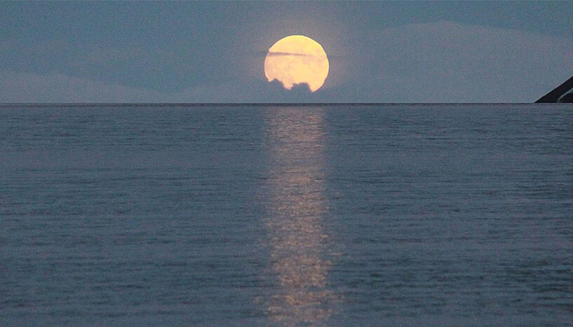 Der Mond geht über dem Meer unter