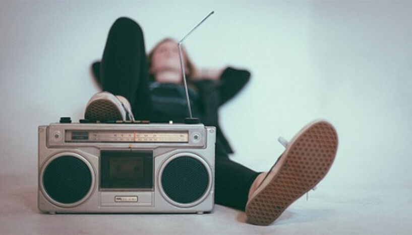 Abb. 1: Person, die auf dem Boden liegt, vor ihr ein Radio