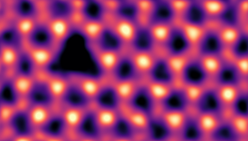 Ein sechseckiges Gitter aus hellen Punkten, die durch weniger helle Punkte verbunden sind. Ein heller Punkt und seine drei Verbindungen fehlen, sodass eine dunkle dreieckige Lücke entsteht.