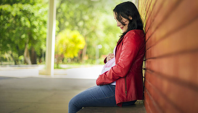 Pregnant woman on a parkbench