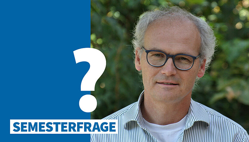 Porträtfoto von Ulrich Technau mit Semesterfrage-Sujet (weißes Fragezeichen auf blauem Balken)