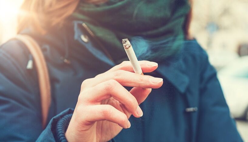 Bild einer Person, die eine Zigarette in der Hand hält.
