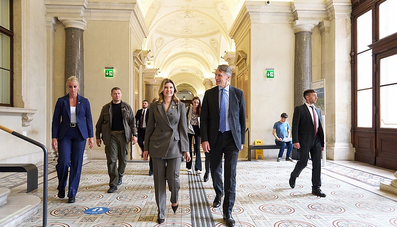 Photo of Olena Zelenska and Sebastian Schütze on their way through the main buidling of the University of Vienna