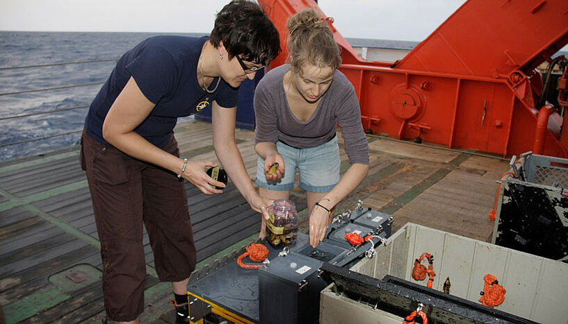 Rebecca Ansorge und Silke Wetzel auf dem Boot – sie entnehmen Proben, die der Tauchroboter gesammelt hat. 