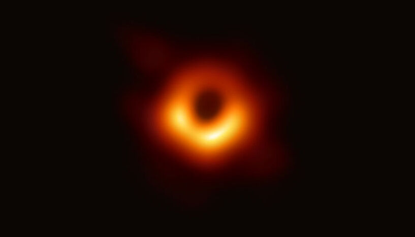Aufnahme eines Schwarzen Lochs - schwarze Scheibe vor hellem Hintergrund
