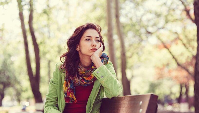 Picture of a woman sitting on a bench in the park.