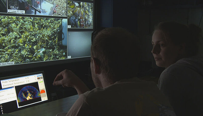 Die ForscherInnen sehen auf einem Bildschirm, was der Tauchroboter unter Wasser filmt. 